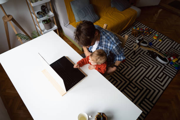istock Modern father working at home while holding his baby son 1326507765