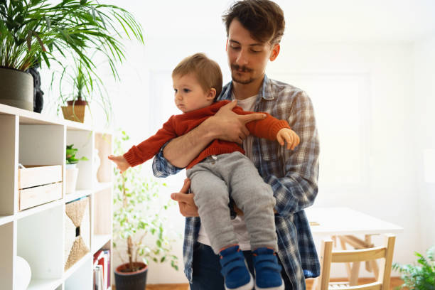 istock Young father holding his baby son at home 1326507793