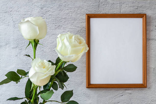 istock Portrait white vertical picture frame mockup with white rose grey concrete wall background. 1326507929