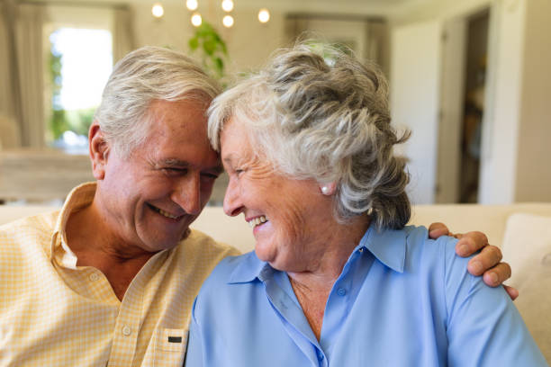 istock Senior caucasian couple sitting on sofa embracing and smiling 1326507963