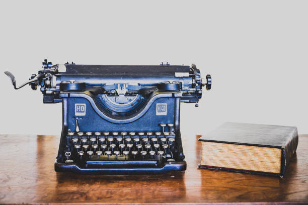 antike schwarze schreibmaschine mit alten buch auf mahagoni holz schreibtisch aus nächster nähe gesehen - typewriter book old retro revival stock-fotos und bilder