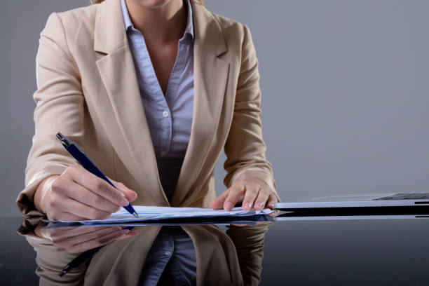 istock Midsection of caucasian businesswoman using laptop and taking notes, isolated on grey background 1326515507