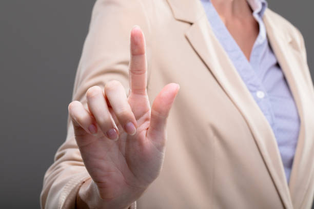 istock Midsection of caucasian businesswoman touching virtual interface on grey background 1326517131