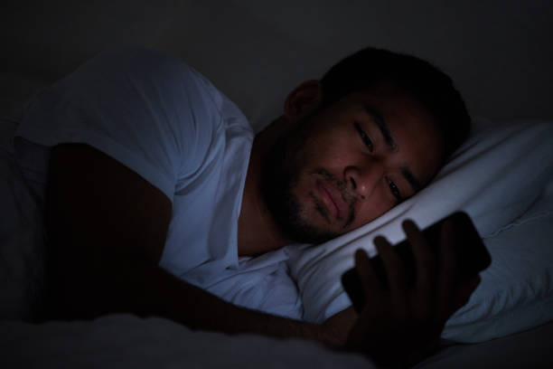istock Cropped shot of a man using his cellphone while lying in bed at night 1326517784