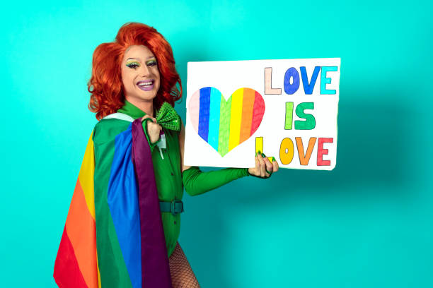 happy drag queen celebrating gay pride holding banner with rainbow flag symbol of lgbtq social movement - travesty imagens e fotografias de stock