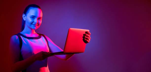 istock futuristic technology neon banner woman laptop 1326528561