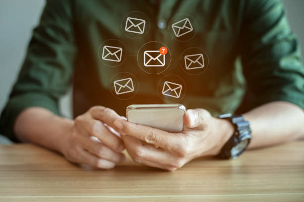 istock Closeup of businessman hands using mobile phone with email icon 1326535041