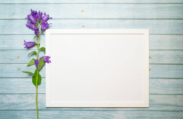 istock Horizontal white frame on a wooden turquoise background for mockup and flowers, copy space 1326536011