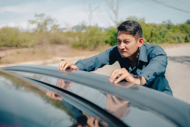 istock Man pushing a broken car breakdown on the road hot day. Car broken concept. 1326542715