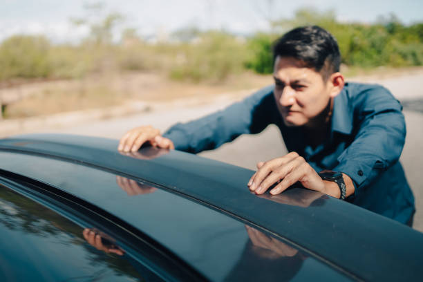 istock Man pushing a broken car breakdown on the road hot day. Car broken concept. 1326542722