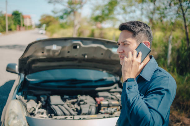 young man calling,  texting for car service on roadside assistance after broken car. Car broken, car breakdown concept.