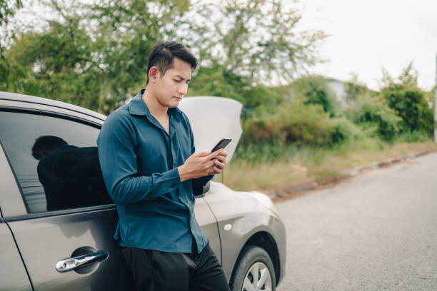 young man calling,  texting for car service on roadside assistance after broken car. Car broken, car breakdown concept.