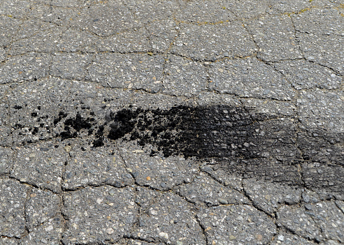 Closeup of fresh burnt rubber that is still smoking from a tire on pavement.