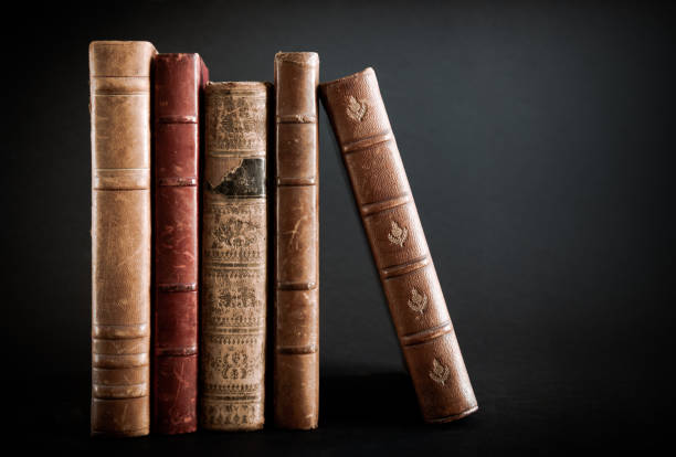 istock Row of old books on black background 1326556362