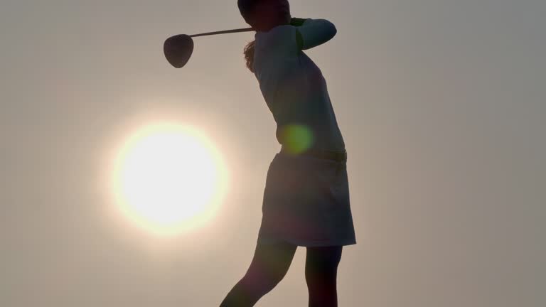 Women in Sport :In silhouette of golfer women hit sweeping and keep golf course in the summer for relax time at sunset.Female golfer happy for successful putt on the green.Sport, Leadership, Success, Passion, Winning, Lifestyle, Perseverance, Integrity, Power, Sports Cinemagraphs