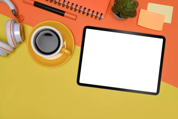 istock Top view digital tablet, coffee cup and sticky notes on colorful background. 1326557043