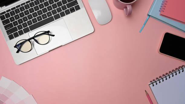 istock Graphic designer workspace with laptop, smart phone, glasses and notebook on pink background. 1326557055