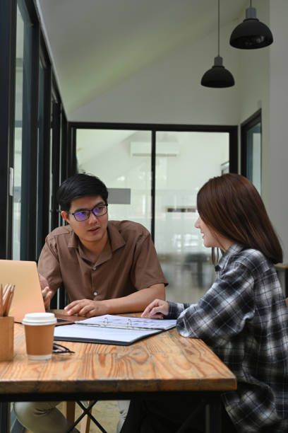 istock Two business people talking project strategy in office. 1326557096