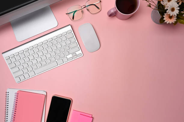 istock Above view designer workspace with, smart phone, glasses and notebook on pink background. 1326557115