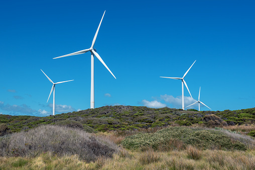 Windmills produce energy on countryside field. Ecofriendly wind turbines generate clean and renewable energy for supporting farmlands