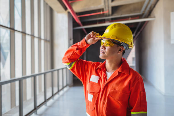 istock Portrait of Asian Construction or Electronics engineer in hardhat wearing safety jacket standing next to window at construction site 1326560870
