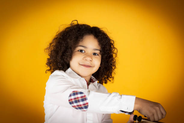 boy with a toy plane on yellow background, travel concept