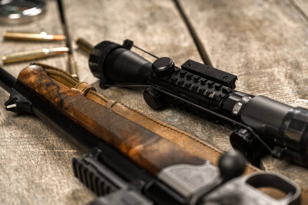 istock The optical sight and shotgun on wooden backgorund 1326562494