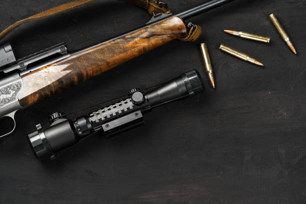 istock The optical sight and shotgun on wooden backgorund 1326563102
