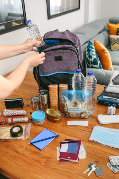 istock Woman putting a water bottle to prepare emergency backpack 1326563697