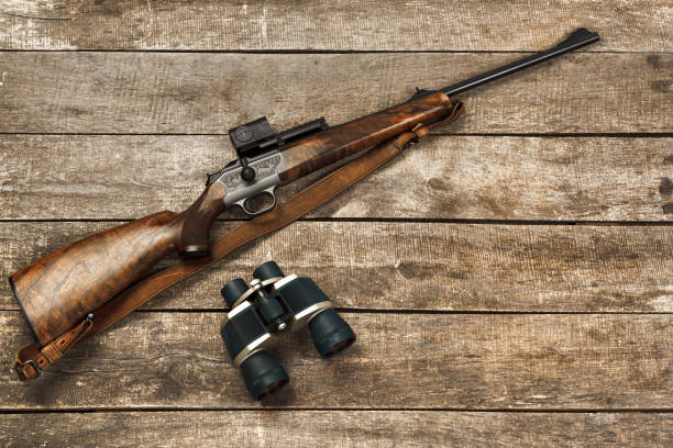 istock Hunting rifle and binoculars on dark wooden background 1326564084