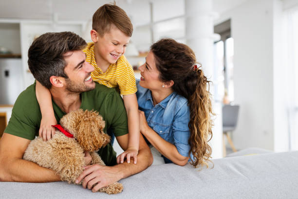 портрет счастливой семьи с собакой весело провести время вместе дома. - family dog happiness pets стоковые фото и изображения