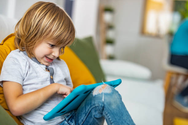 istock Shocked boy watching cartoons on touchpad at home. 1326565666