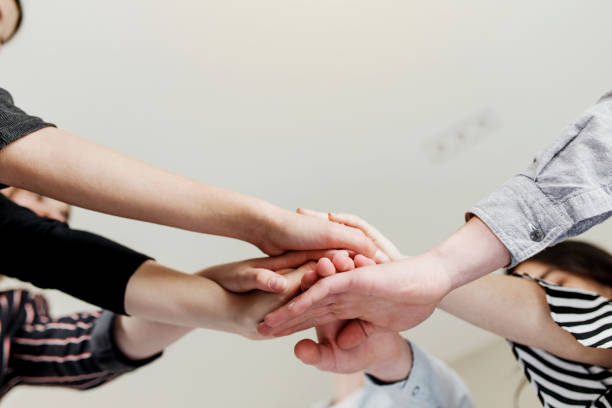 istock Group of people doing handshake and cross hands 1326569078