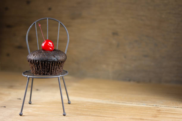 cupcake al cioccolato su sedia, atmosfera estiva, giornata calda, concetto di stile di vita, spazio di copia. - cupcake crumb sweet wrapper chocolate foto e immagini stock