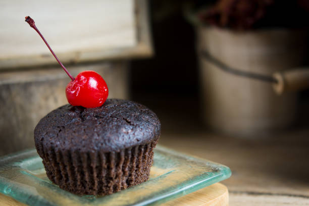 cupcake al cioccolato in un piatto di vetro, atmosfera estiva, giornata calda, concetto di stile di vita. - cupcake crumb sweet wrapper chocolate foto e immagini stock