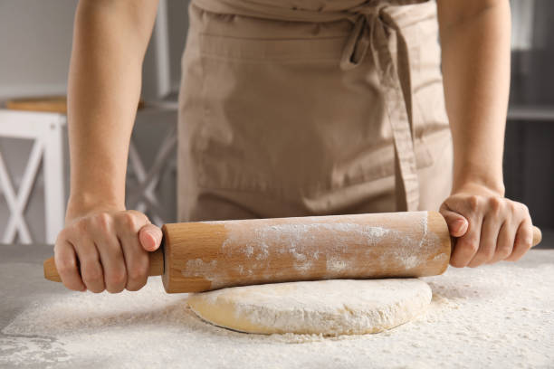 istock Woman rolling fresh dough at table, closeup 1326570361
