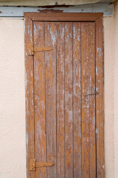 istock Old rusty hinges on brown wooden cracked door close up 1326570513