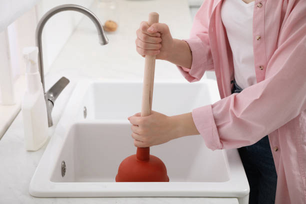 femme utilisant un piston pour dévier le drain de l’évier dans la cuisine, gros plan - lavabo et évier photos et images de collection