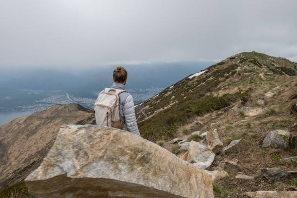 istock Young man hiking on mountain ridge, overcast sky 1326579672