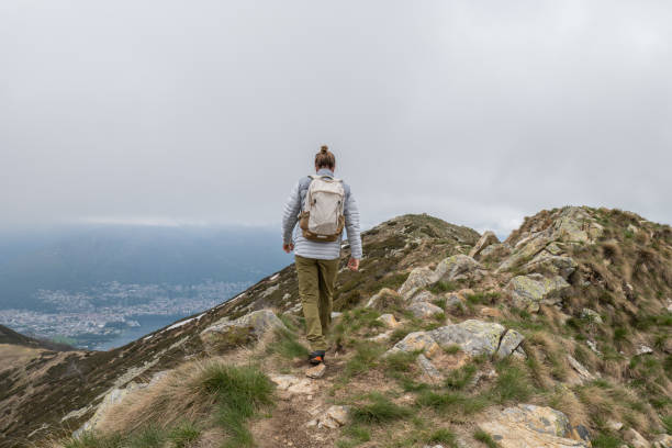 istock Young man hiking on mountain ridge, overcast sky 1326580260