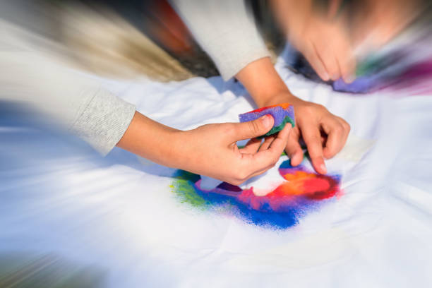 istock Creating your own t-shirt workshop outside. Hand applying paint on shirt 1326583302