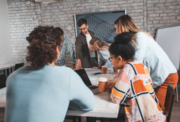 istock Group of young people discussing architectural designs in the creative office. 1326585544