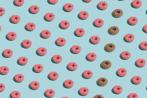 istock Creative summer vibes concept with tasty pink and brown doughnuts on bright blue background. Sweet, delicious food idea, minimalistic irregular pattern composition. 1326606922