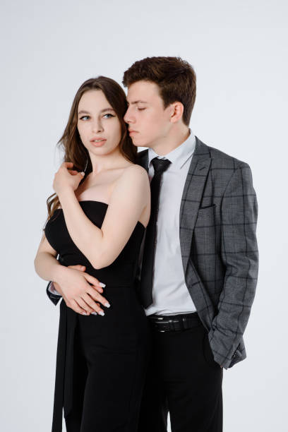 istock young couple in suits on white background. 1326607314