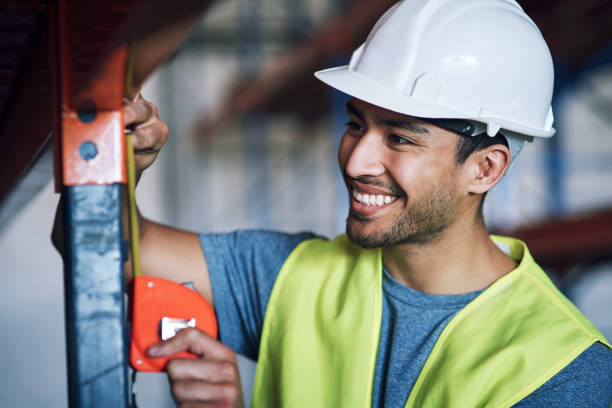 istock Shot of a young builder using a measuring tape at a construction site 1326611701