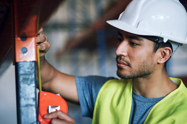 istock Shot of a young builder using a measuring tape at a construction site 1326611704