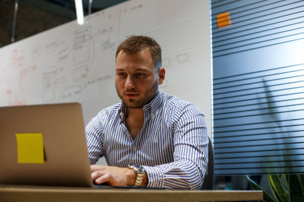 istock Young man is sitting in the office and using laptop. 1326611769