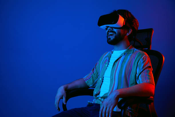 istock Man in modern VR headset looking away with happy expression while sitting 1326613789