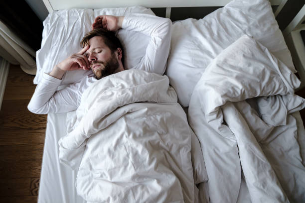 istock Bearded man sleeps restlessly in bed, he is alarmed and had a terrible nightmare. 1326614022