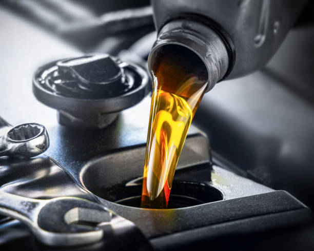 después de cambiar el aceite, vierta el aceite fresco del motor - motor oil bottle fotografías e imágenes de stock